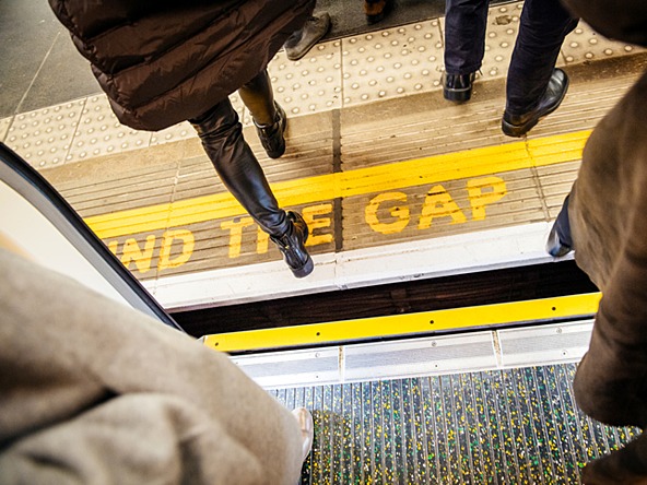 Mind the gap notice on platform on London Underground, passengers getting off train
